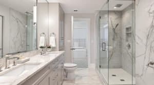 A bright and modern bathroom in New Westminster, BC, featuring a double vanity with marble countertops, a glass-enclosed shower with built-in shelving, and neutral-toned cabinetry.